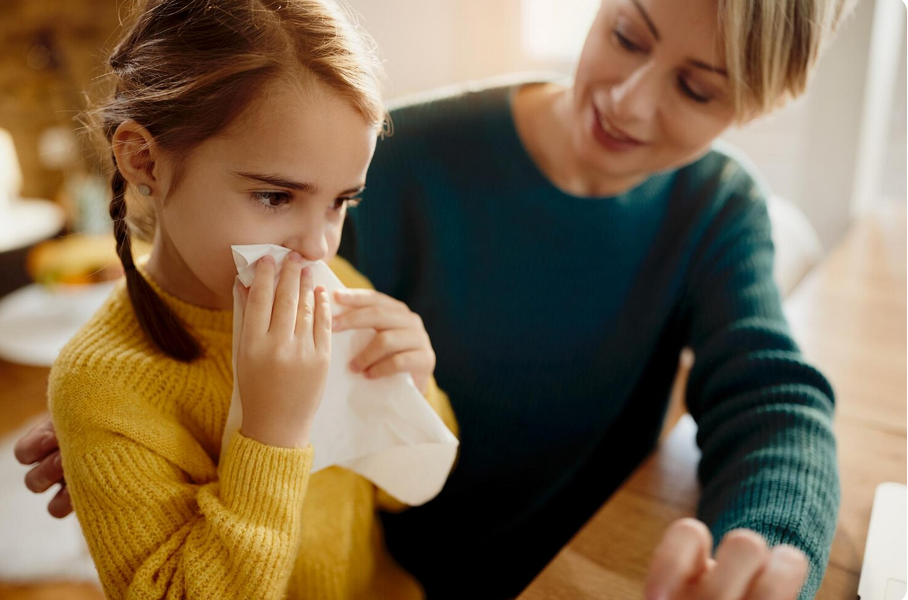 mamma che guarda bambina mentre si asciuga il naso
